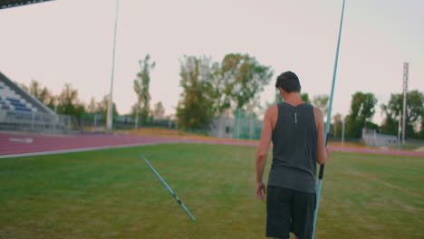 Slow-motion:-a-Male-athlete-at-the-stadium-concentrates-and-prepares-to-do-a-javelin-throw.-Attitude-and-serious-expression.-Goes-around-collecting-spears.-Training-of-a-javelin-thrower